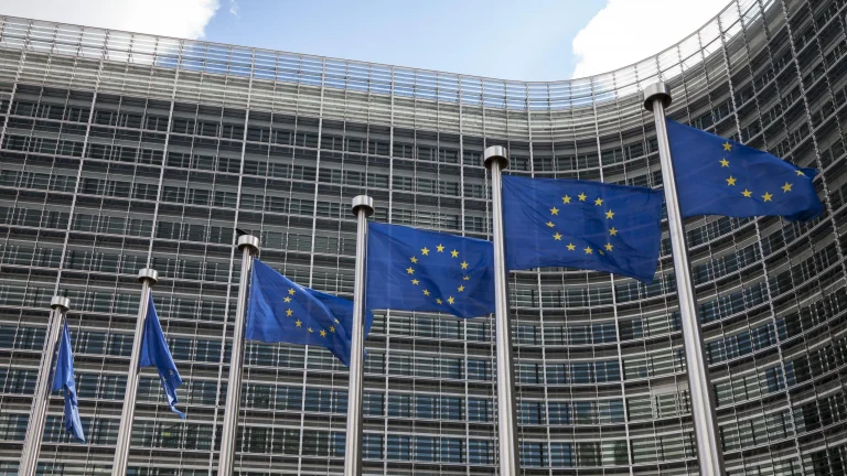 EU flags outside the European Commission building in Brussels representing AMLA regulatory technical standards for EU AML compliance